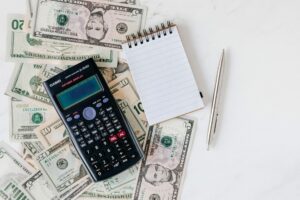 using a calculator and notebook to calculate retirement fund fees