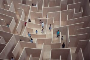 People navigating their way through a wooden maze with no exit in sight