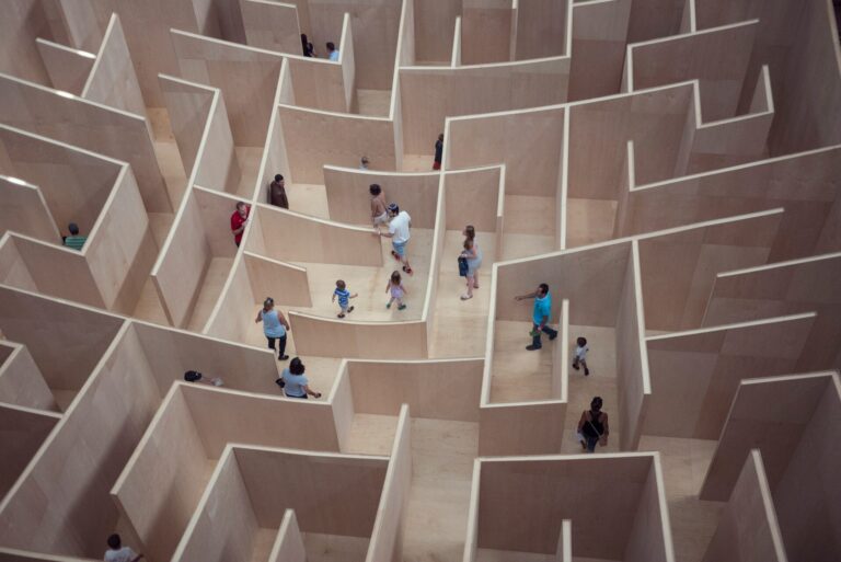 People navigating their way through a wooden maze with no exit in sight