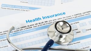 Health insurance enrollment form with a stethoscope resting on top, symbolizing healthcare coverage, medical planning, and insurance decisions.