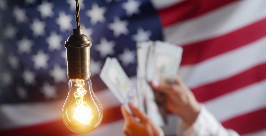 Glowing Edison light bulb on american USA flag background. Woman counting money dollars. Electricity price, bills, energy crisis, raising tariffs. High quality