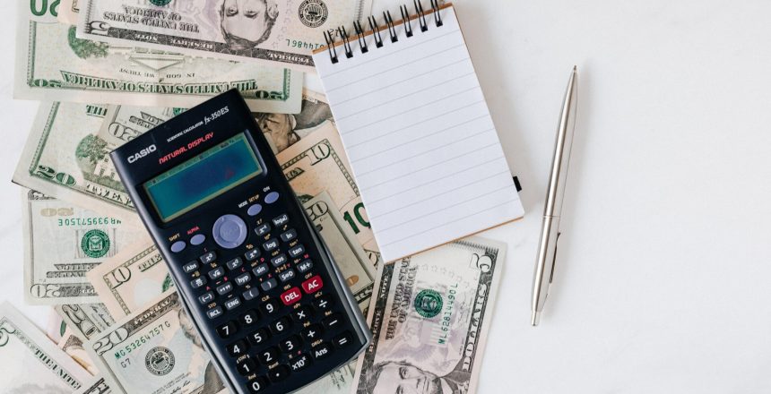 using a calculator and notebook to calculate retirement fund fees
