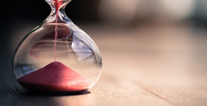Red sand in an hourglass. Time may be ticking away, but that doesn't mean you have to mistime a stock market valuation.